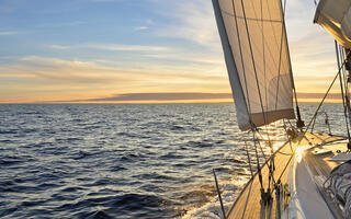 Bateau à voile naviguant dans la mer Méditerranée au coucher du soleil