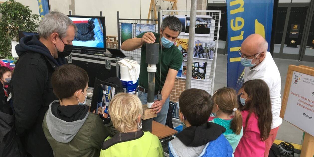 <p>Animation du stand Ifremer au village des sciences des Capucins, à Brest, lors de la Fête de la Science. Le public apprend le fonctionnement d'un carottier, grâce à une maquette qui simule le prélèvement de sédiments dans les fonds océaniques.</p>