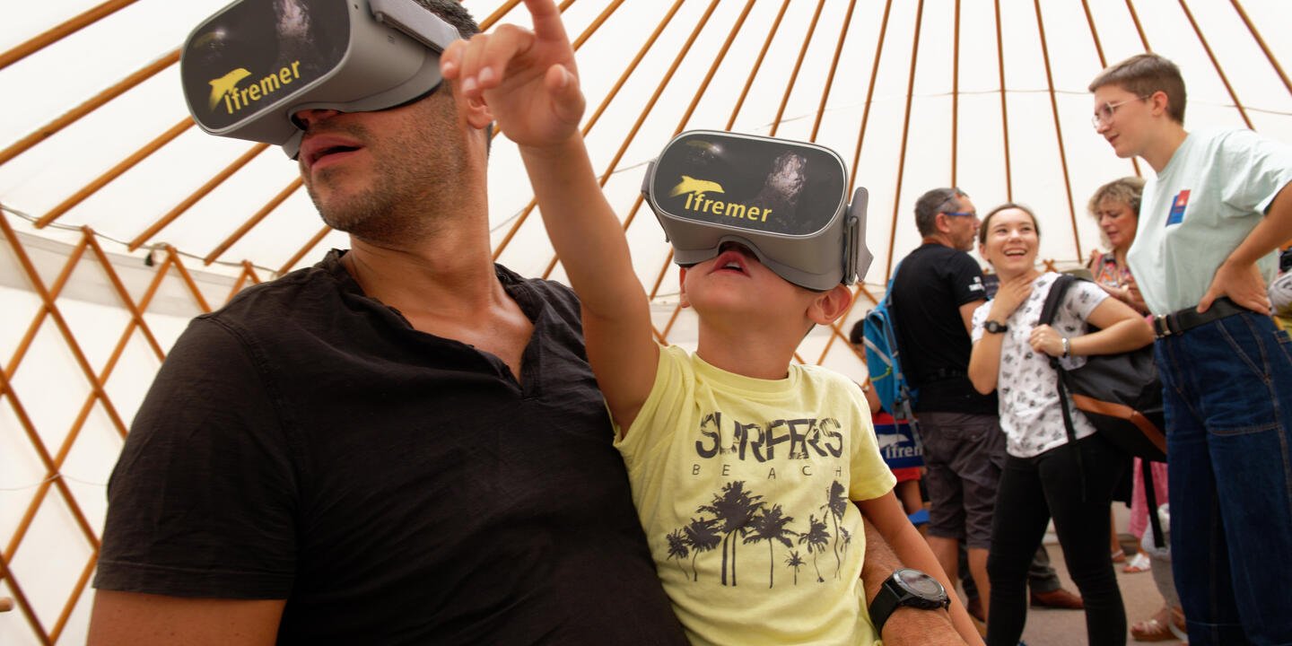 Un enfant et son père avec un casque VR.