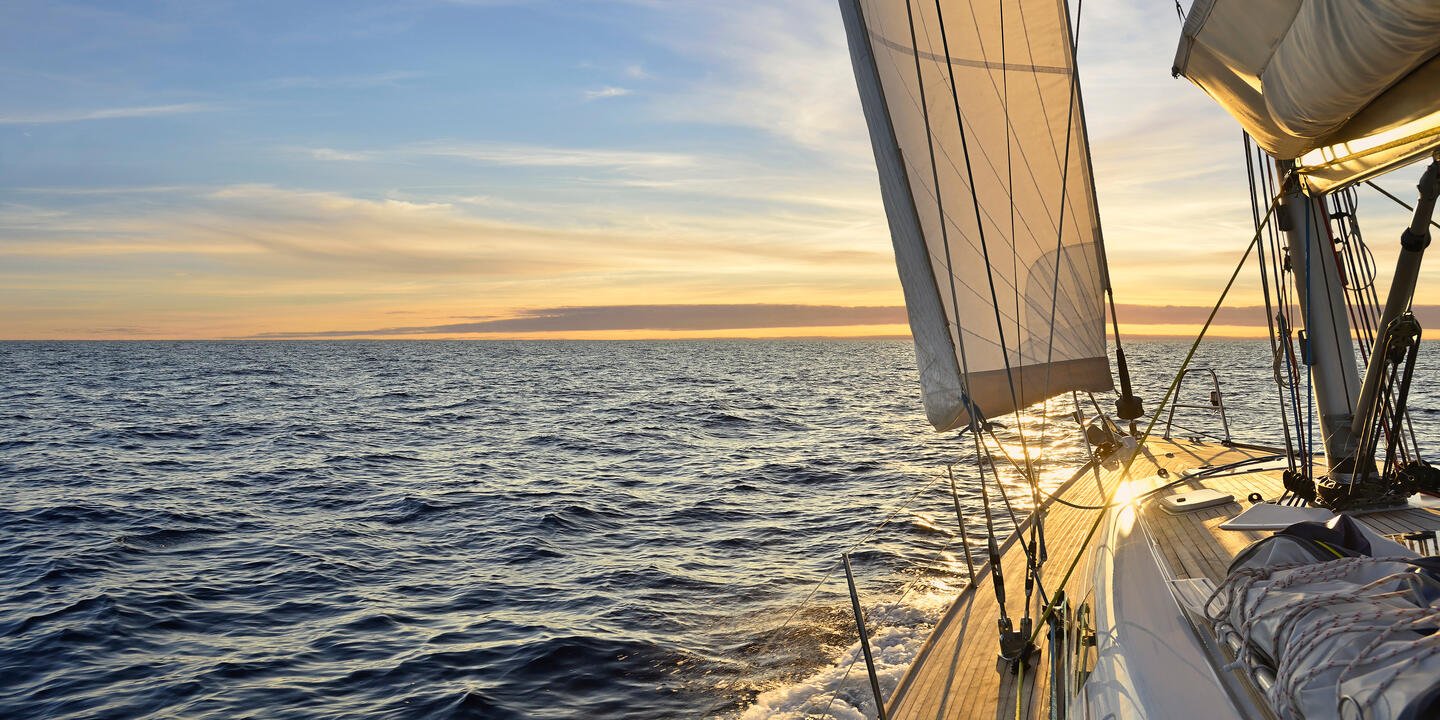 Bateau à voile naviguant dans la mer Méditerranée au coucher du soleil