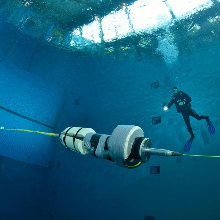 Vue dans l'eau, le HROV Ariane au premier plan avec un plongeur derrière